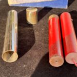metal tube with cap and two firecrackers for a magic trick