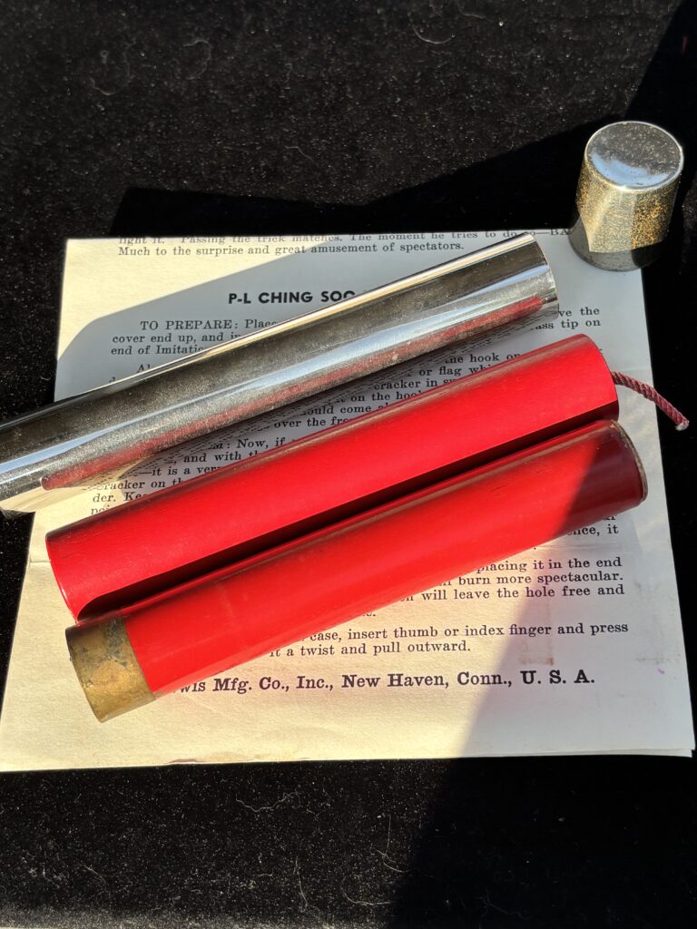 metal tube with cap and two firecrackers for a magic trick
