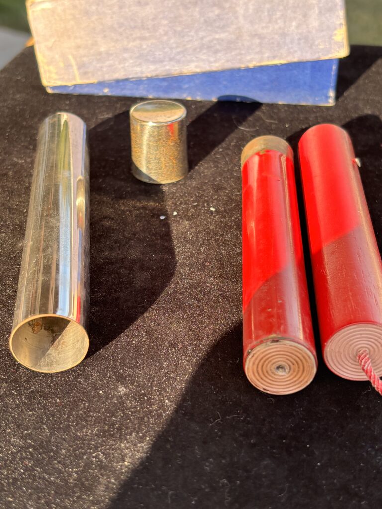 metal tube with cap and two firecrackers for a magic trick