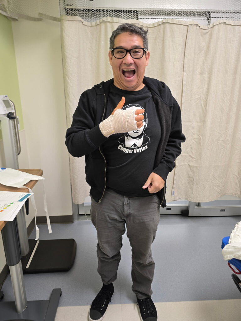 A magician in hospital giving thumbs up